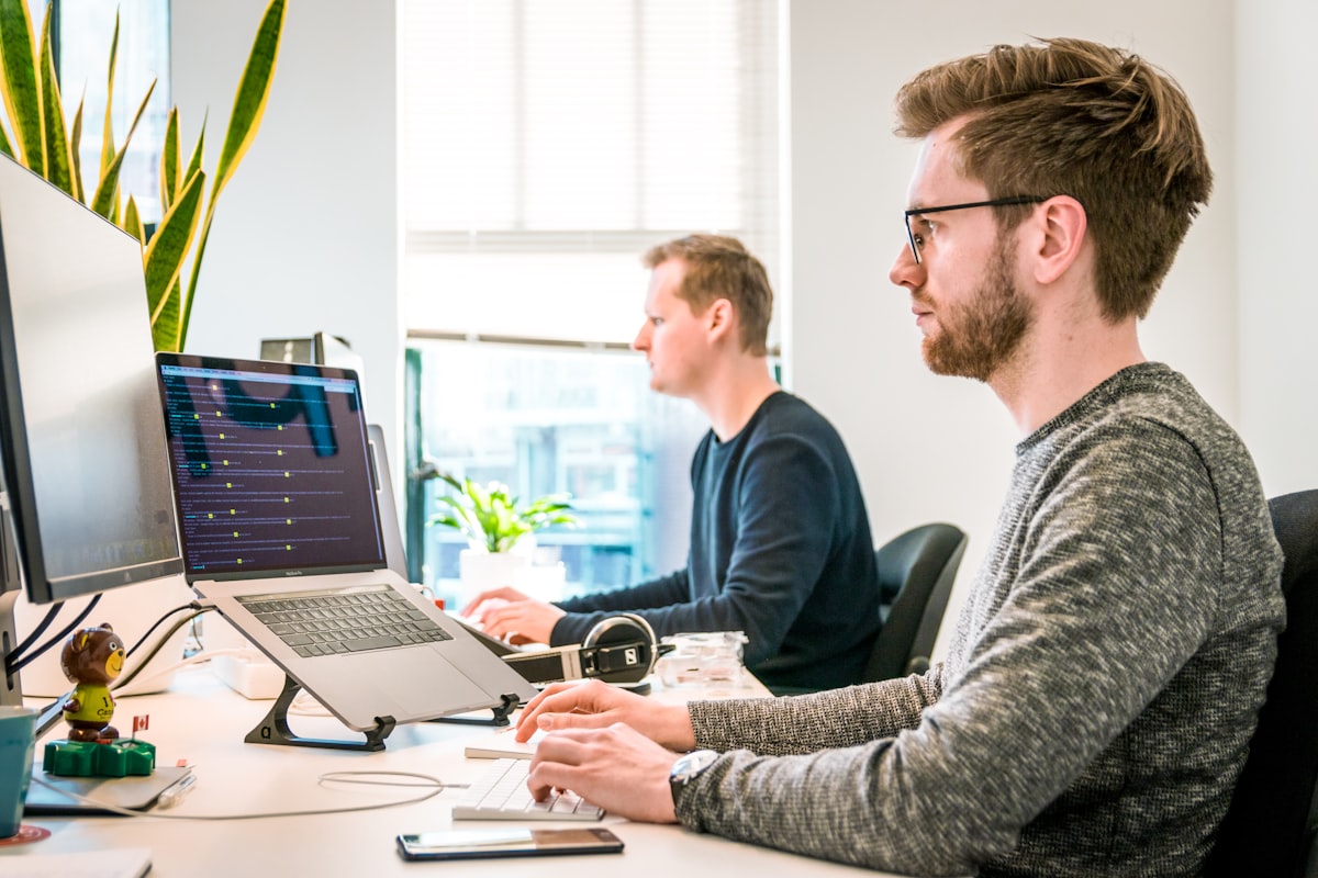 Marketing team analyzing influencer campaign analytics data on laptop showing micro vs macro influencer ROI dashboard